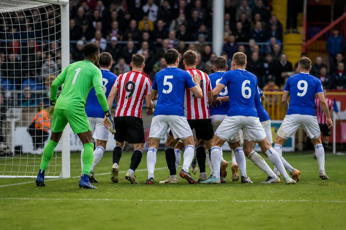 Corner en préparation, joueurs massés dans la surface près de la ligne de but